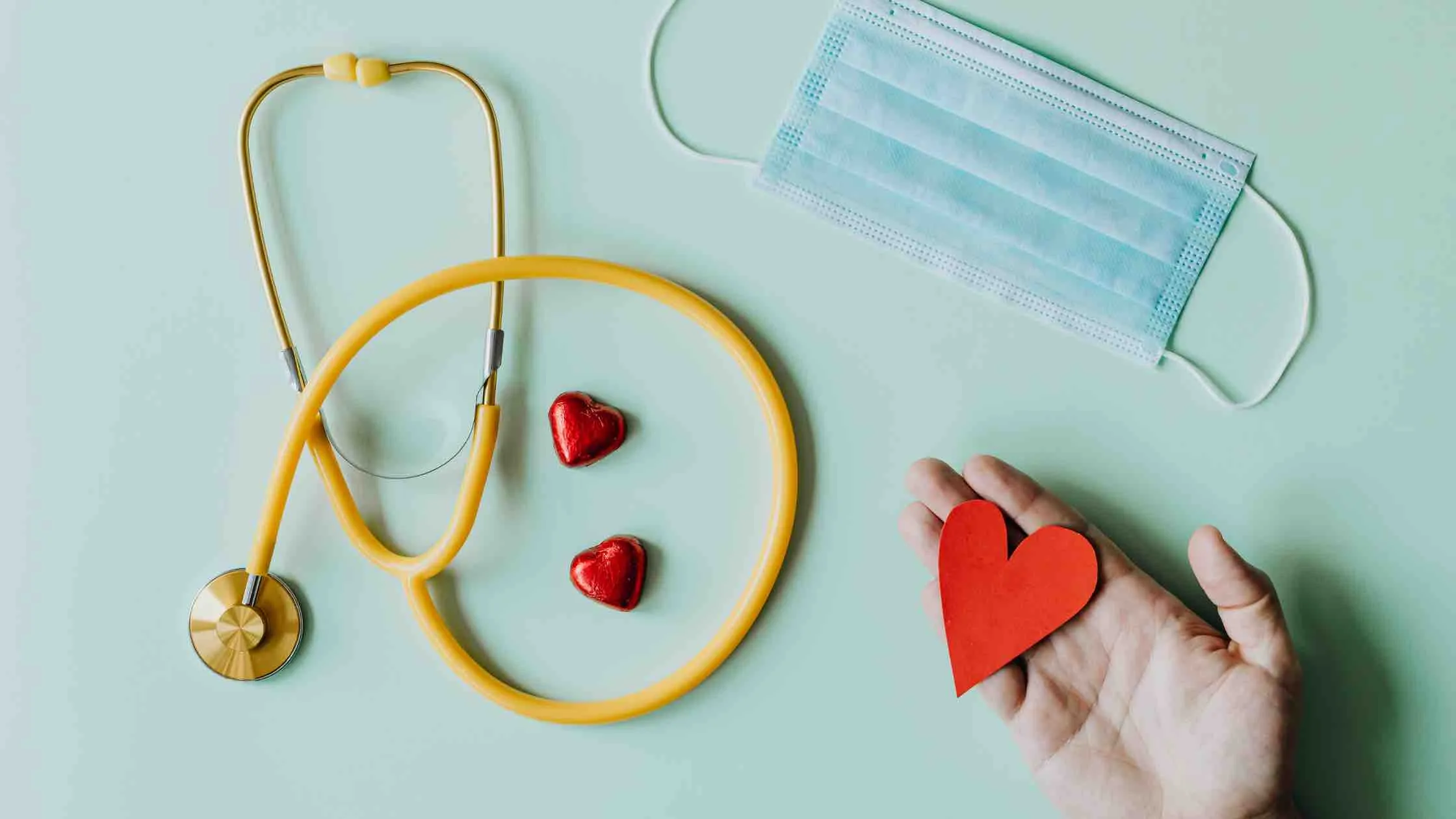 stethoscope and a hand holding a heart